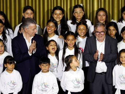 El expresidente Juan Manuel Santos junto a Rodrigo Londoño, líder del partido Comunes, aplauden junto al Coro de hijas e hijos por la paz durante la conmemoración de los siete años de la firma del acuerdo de paz con las extintas FARC.