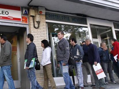 Desempleados esperando a las puertas de una oficina de empleo.