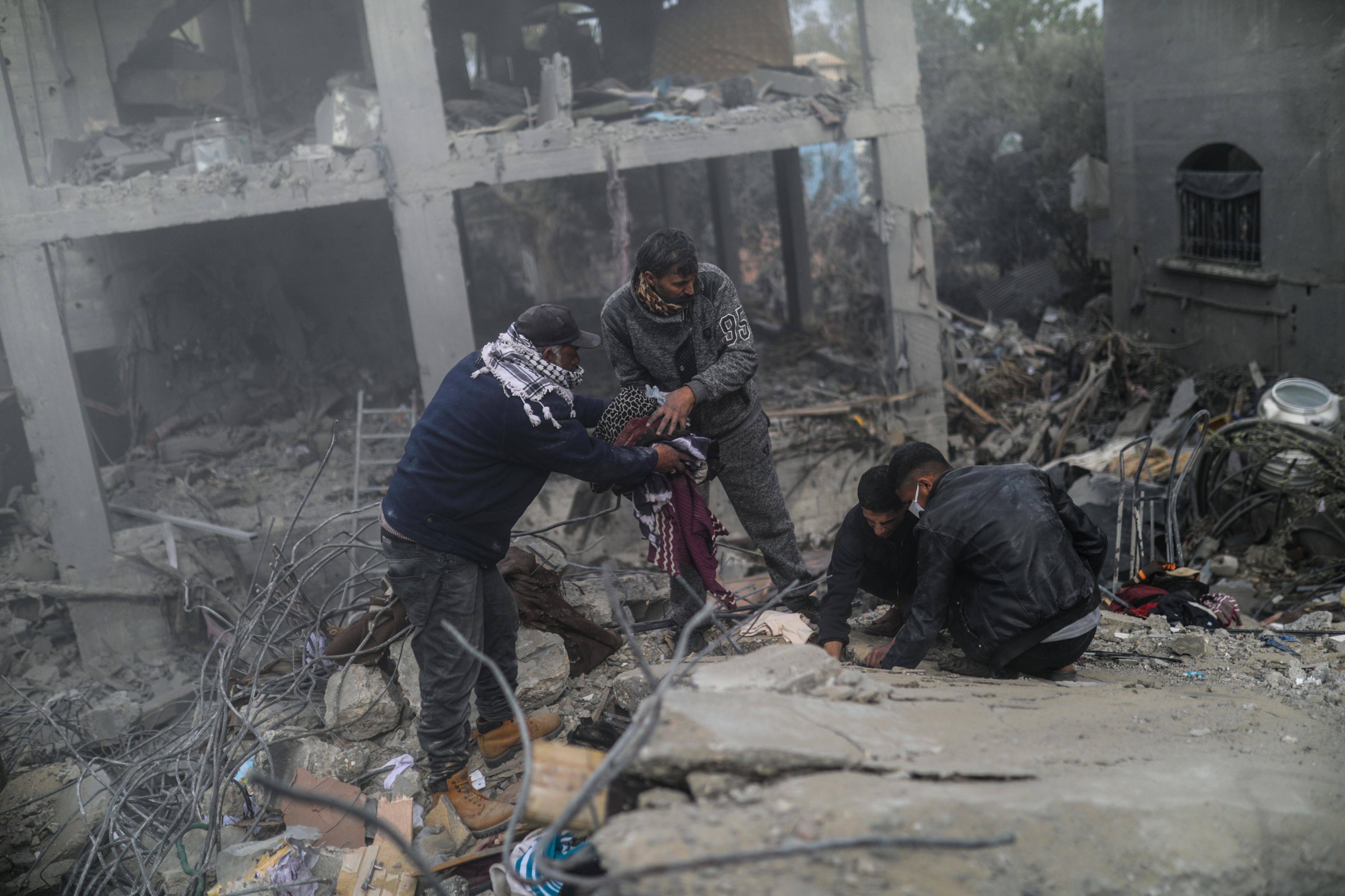 Palestinos buscan cuerpos y supervivientes entre los escombros de una casa destruida tras un ataque aéreo israelí en Deir Al Balah, sur de la Franja de Gaza, este 23 de febrero de 2024.