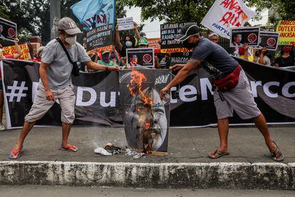 Activistas filipinos queman un cartel con la imagen de los candidatos electorales Sara Duterte y Ferdinand Marcos Jr durante una protesta