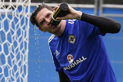 El delantero de Irlanda del Norte, Kyle Lafferty, bebe agua durante el entrenamiento en Saint George de Reneins.