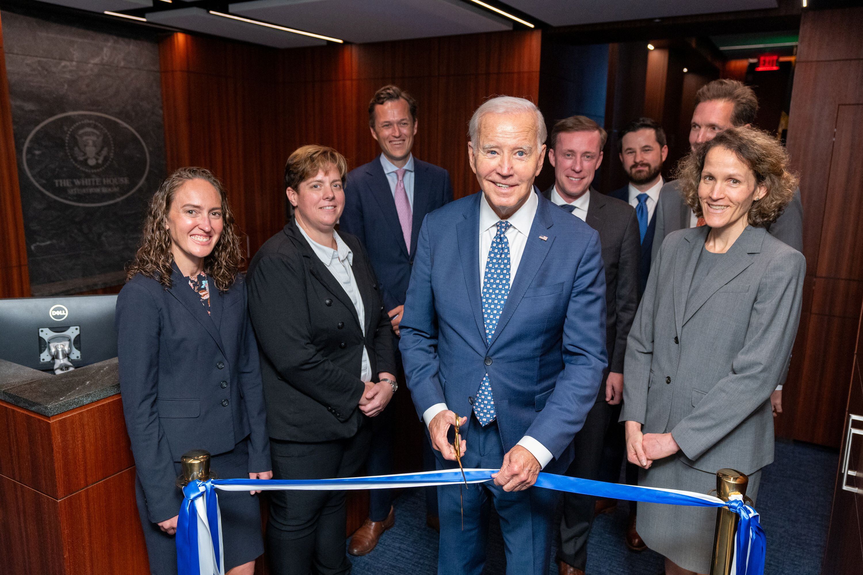 El presidente Joe Biden, al cortar la cinta inaugural de la renovada sala de crisis de la Casa Blanca.