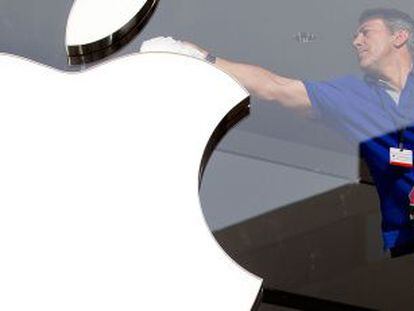 Un trabajador limpia el logotipo de Apple