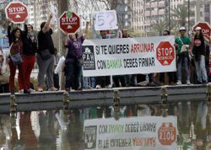Un grupo de activistas de la plataforma Stop Desahucios protesta a las afueras del Palacio de Congresos de Valencia.
