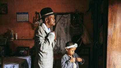 Una de las fotos que componen el reportaje gráfico ganador del World Press Photo 2024 en el que se ve a Dada Paul y su nieta Odliatemix, de cinco años, se preparan para ir a la iglesia el domingo por la mañana en su casa de Madagascar,