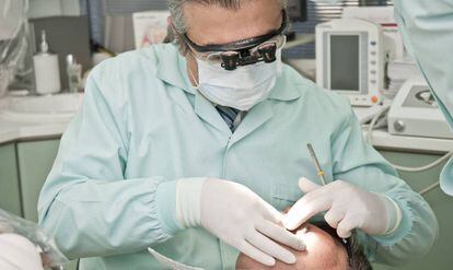 Un odontólogo atiende a un paciente.