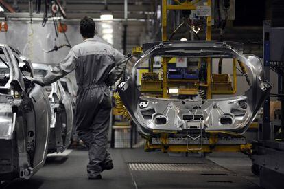 Un trabajador en la cadena de montaje de Peugeot en Montbeliard ( Francia)