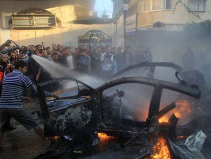Varios hombres tratan de apagar el fuego del vehículo de Yabari.