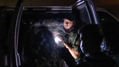 Un agente de la Patrulla Fronteriza inspecciona un vehículo con menores migrantes el 9 de diciembre de 2021 en Yuma (Arizona).