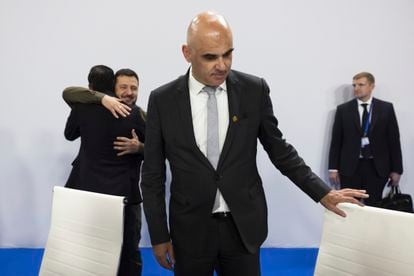 El presidente de Suiza, Alain Berset, toma asiento. Al fondo, Volodímir Zelenski abraza a Rishi Sunak (de espalda).