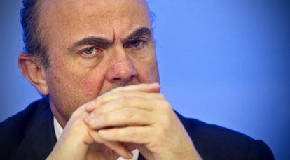 El ministro de Economía, Luis de Guindos, ayer en la sede del PP en Madrid con los portavoces del área económica