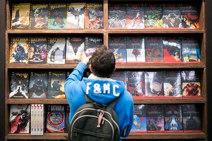 Un adolescente elige un cómic en una tienda.