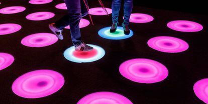 Dos personas recorren una instalación de arte con luces LED durante la presentación de una experiencia interactiva Pop-art 'Luces y Arte' en Kuala Lumpur, Malasia. 
