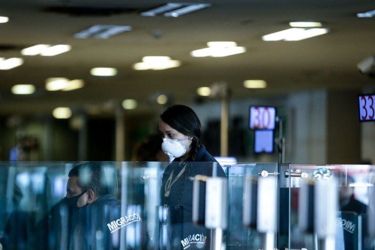 Una empleada con mascarilla en el aeropuerto El Dorado de Bogotá.