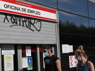 Dos jóvenes caminan delante de una oficina de empleo en Madrid.