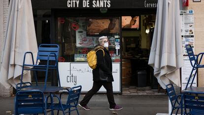 Una mujer pasa ante la terraza de un bar en una calle de Barcelona, el pasado febrero.