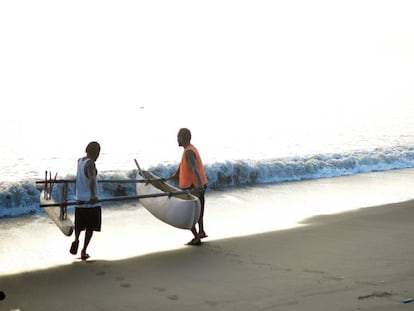 Dos pescadores de Vanuatu lanzan al agua su embarcación.