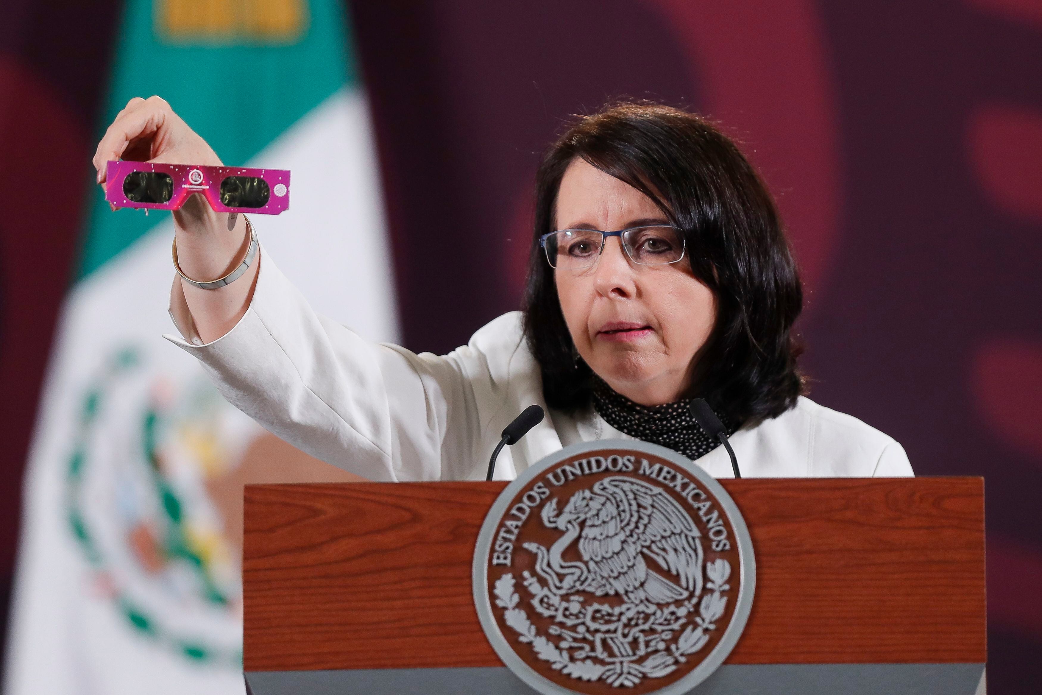 La directora del Conahcyt, María Elena Álvarez-Buylla, muestra unas gafas para la observación del eclipse.