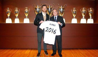Xabi Alonso posa con Florentino después de la firma