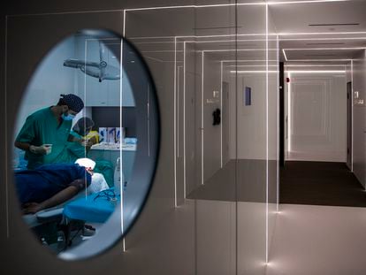 Varios sanitarios operan a un paciente en uno de los quirófanos del Hospital Capilar de Madrid.