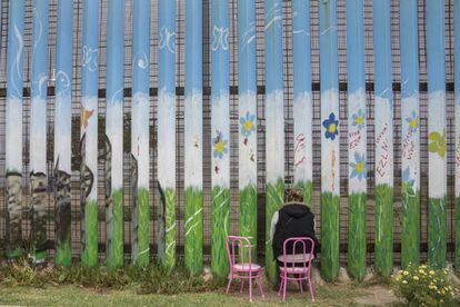 Una mujer espera reencontrarse a trav&eacute;s del muro con su marido en Tijuana.