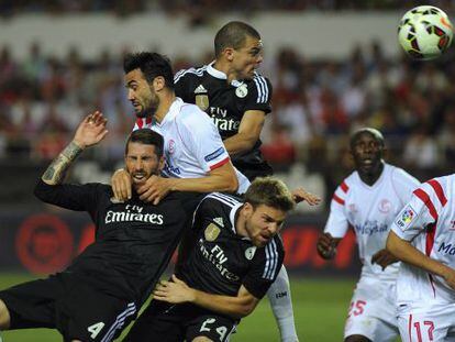 Jugadores del Sevilla y el Madrid luchan en un córner.