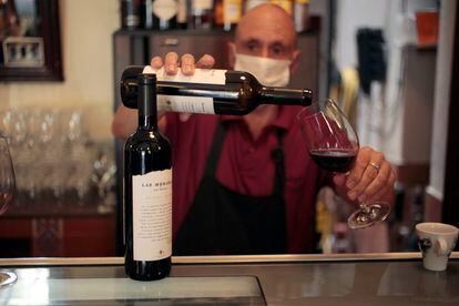 Manolo sirve una copa de vino de Madrid en la taberna Bodegas Rosell.