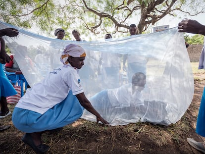 Reparto de mosquiteras para protegerse de la malaria en una comunidad rural de Kenia.