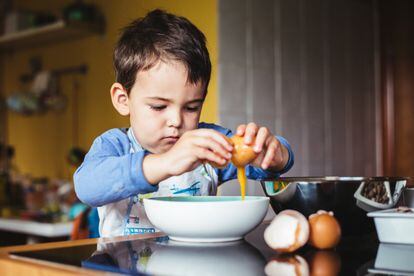 Un niño de tres años se divierte en un taller de cocina para aprender a hornear y hacer pasteles.