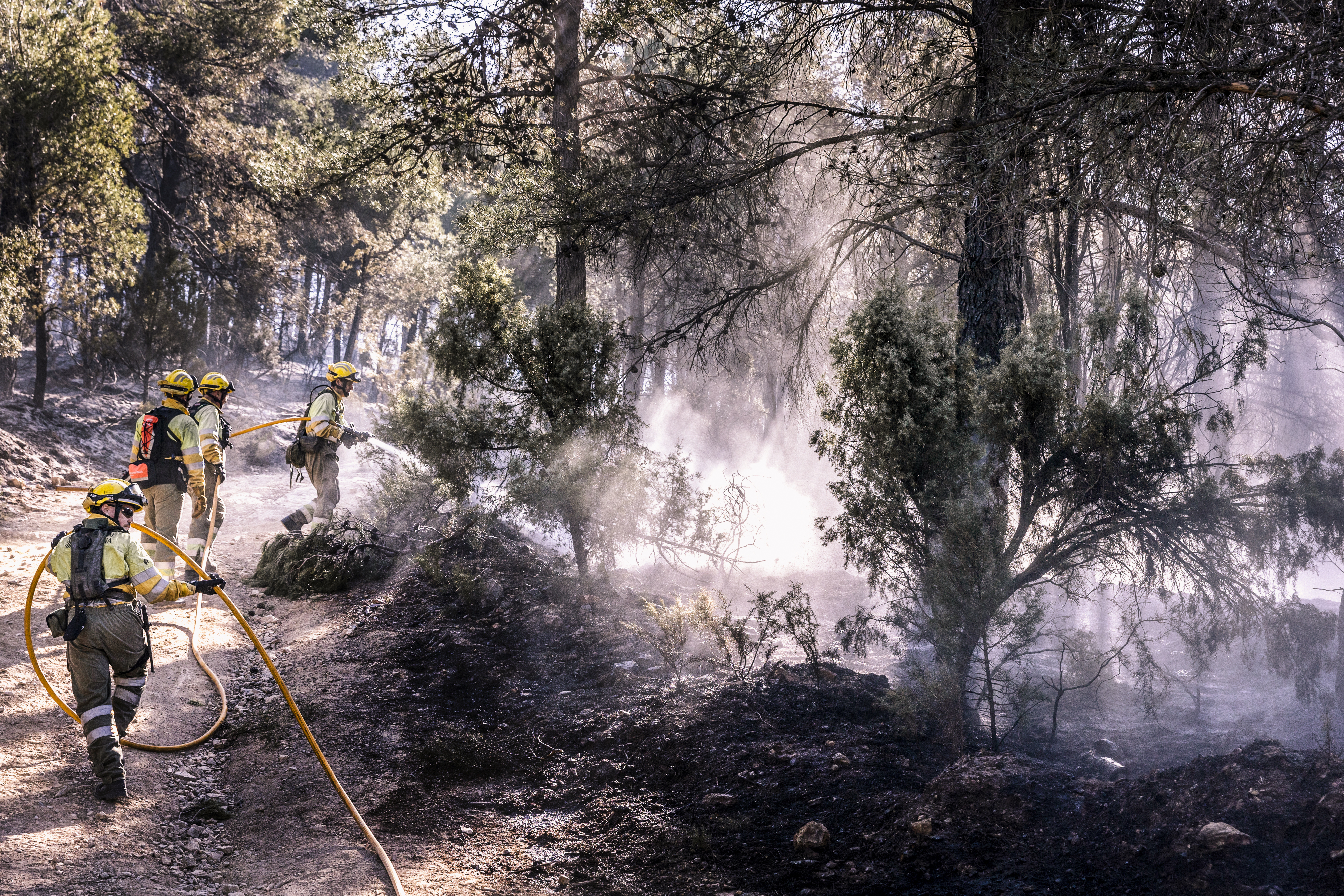 Bomberos refrescan los alrededores de Montán, este miércoles.