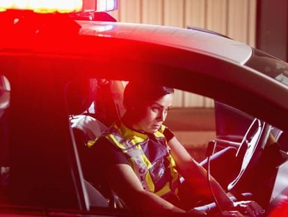 Una polic&iacute;a, en el interior de un coche patrulla.