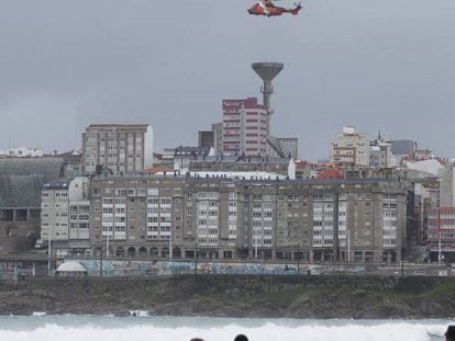 Un helicóptero rastrea la zona de la playa de Orzán, en A Coruña, este viernes.
