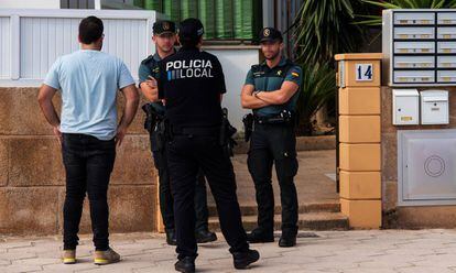 Fuerzas de seguridad en el portal de la vivienda donde una mujer ha sido asesinada, este domingo, en Mallorca.