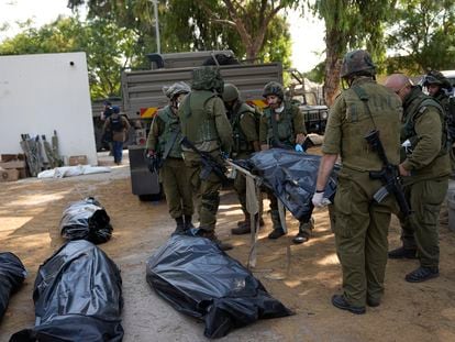 Los soldados israelíes transportan un cadáver en el kibutz de Kfar Aza, este martes.