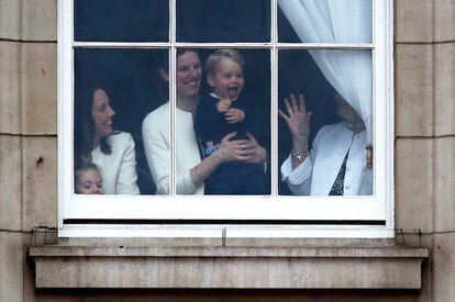 El príncipe Jorge de Cambridge con su cuidadora María Teresa Turrión Borrallo en una de las ventanas de Buckingham Palace.