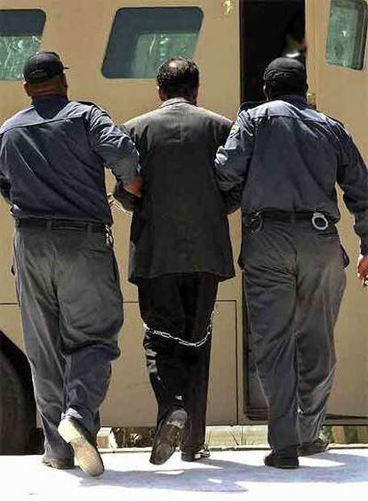 Sadam Husein es conducido hacia el tribunal especial iraquí que lo ha juzgado, en julio de 2004.