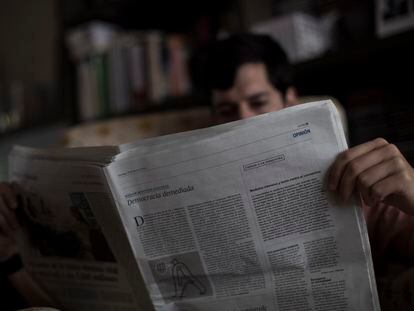 Un lector, con un ejemplar del diario EL PAÍS.