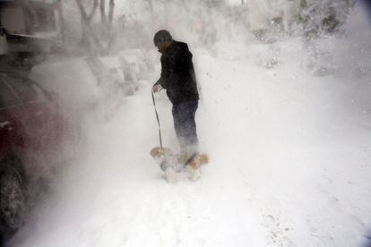 El nuevo alcalde de Nueva York, Bill de Blasio, ha pedido a los neoyorkinos que se queden en casa. En la imagen, un hombre camina con su perro entre la nieve en Nueva York.
