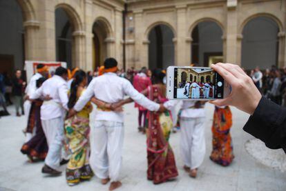 Una espectadora graba a los bailarines adivasis.