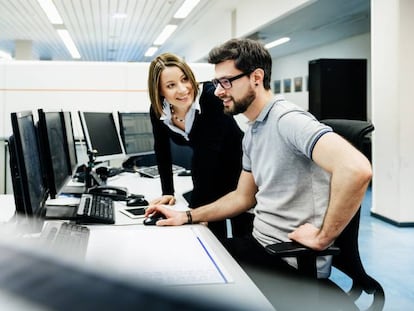 Empleados de una compañía ante el ordenador con el que trabajan cada día. 