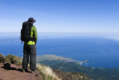 Un excursionista disfrutando de las vistas en la isla de Rishiri-to, en Hokkaido (Japón).