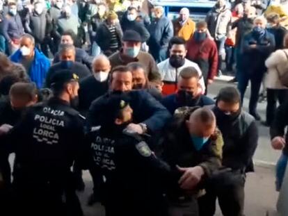 Momento en el que un grupo de personas supera la barrera policial en el Ayuntamiento de Lorca, este lunes.