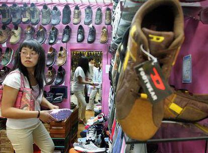 Una consumidora china se prueba zapatos en una tienda en Pekín.
