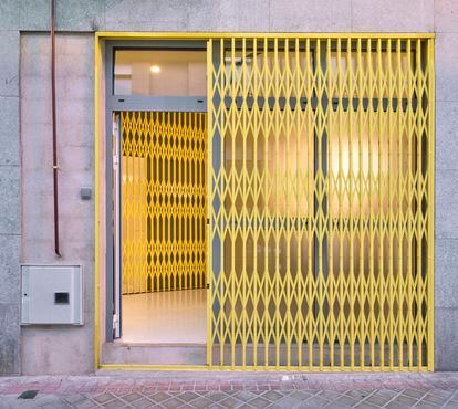 Una verja amarillo chillón sirve de entrada a la vivienda-estudio de Kaydy Cain en el barrio de Carabanchel (Madrid).                      