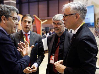 El ministro Álvaro Nadal conversa con el director general de Turismo de la Generalitat, Octavi Bono, en Fitur.