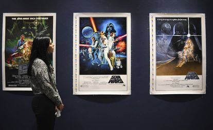 Una empleada de Sothebys observa unos carteles originales de las primeras películas de Star Wars que pondrá a subasta.