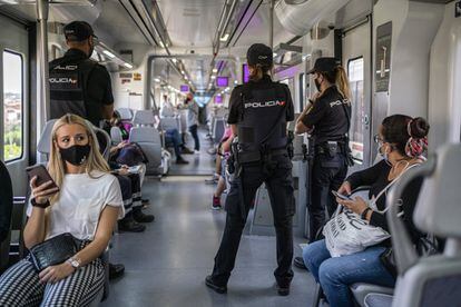 Varios agentes de controla el interior de un tren de Cercanías en las proximidades de la estación de Entrevías de Madrid. 