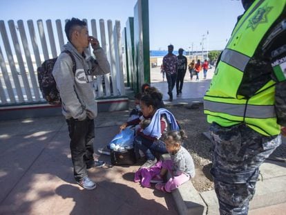 Migrantes en el cruce fronterizo de El Chaparral, en Tijuana, este domingo.