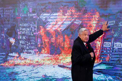 El presidente de México, Andrés Manuel López Obrador, muestra una fotografía de las protestas del 8-M.