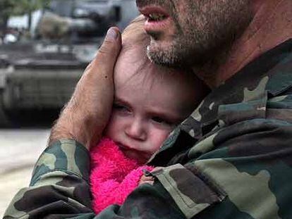 Un soldado de Osetia del Sur abraza a un bebé en Dzhava.